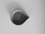 Modern drop-shaped black concrete incense cone dish on white background