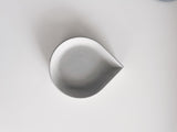 Modern drop-shaped white concrete incense cone dish on white background